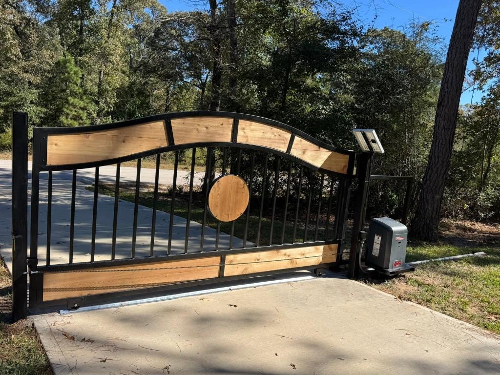 Arched steel and cedar sliding gate with round medallion — Access Pro Gate Company