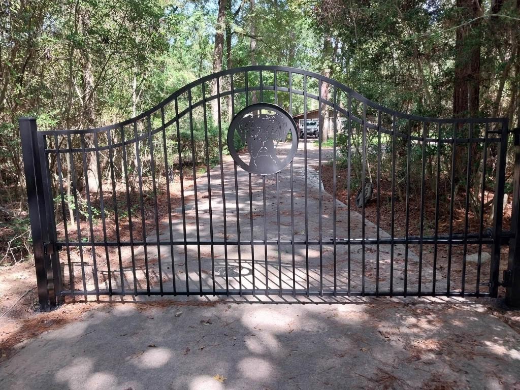 Full view of custom arched iron gate with bulldog medallion installed by Access Pro Gate Company